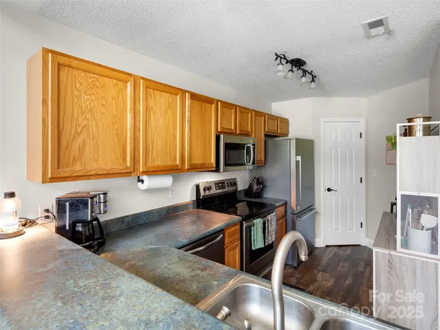a kitchen with stainless steel appliances granite countertop a sink refrigerator stove and microwave
