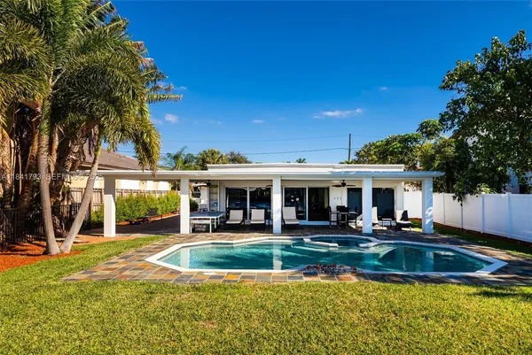 a view of a house with swimming pool and sitting area