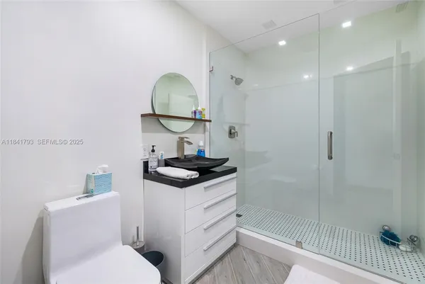 a bathroom with a sink a toilet and shower