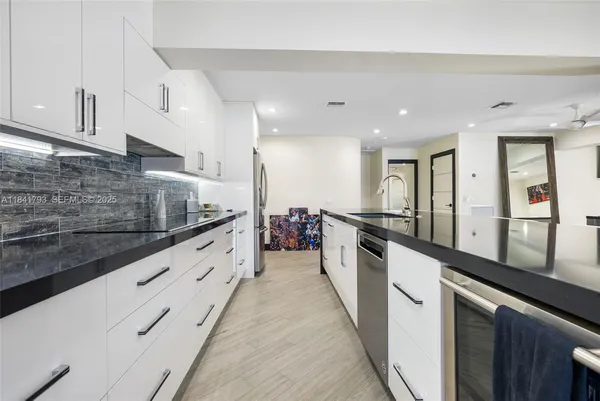 a large white kitchen with stainless steel appliances