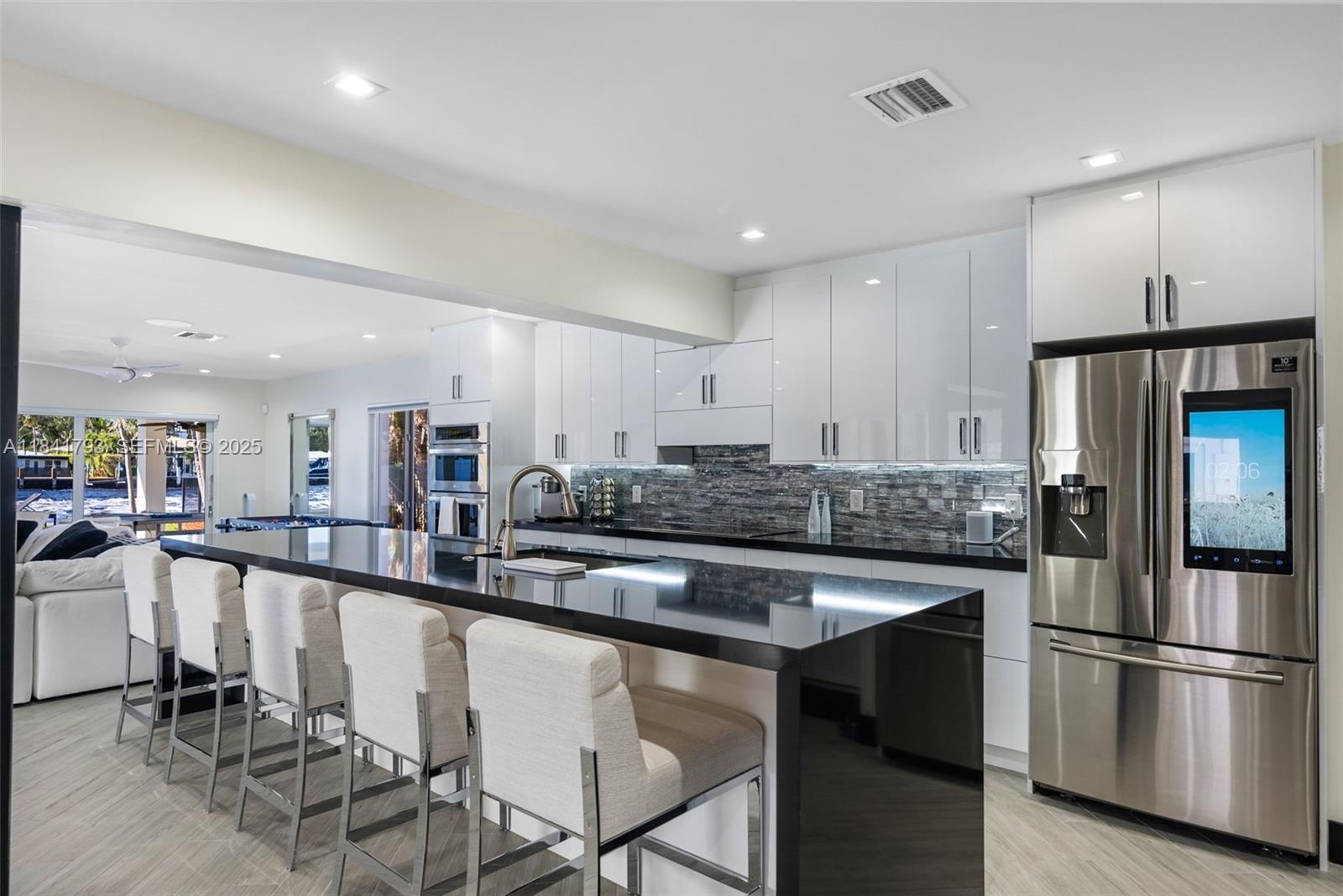 517 South Riverside Drive Pompano Beach, FL 33062 - Photo 8 of 21 a kitchen with stainless steel appliances granite countertop a table chairs sink and cabinets