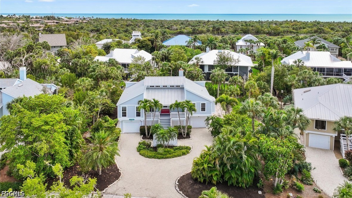 an aerial view of residential houses with outdoor space and trees