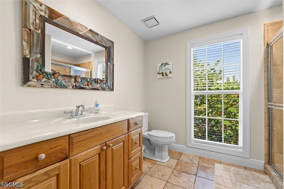 5304 Ladyfinger Lake Road Sanibel, FL 33957 - Photo 24 of 48 a bathroom with a toilet a sink a mirror a window and next to a window