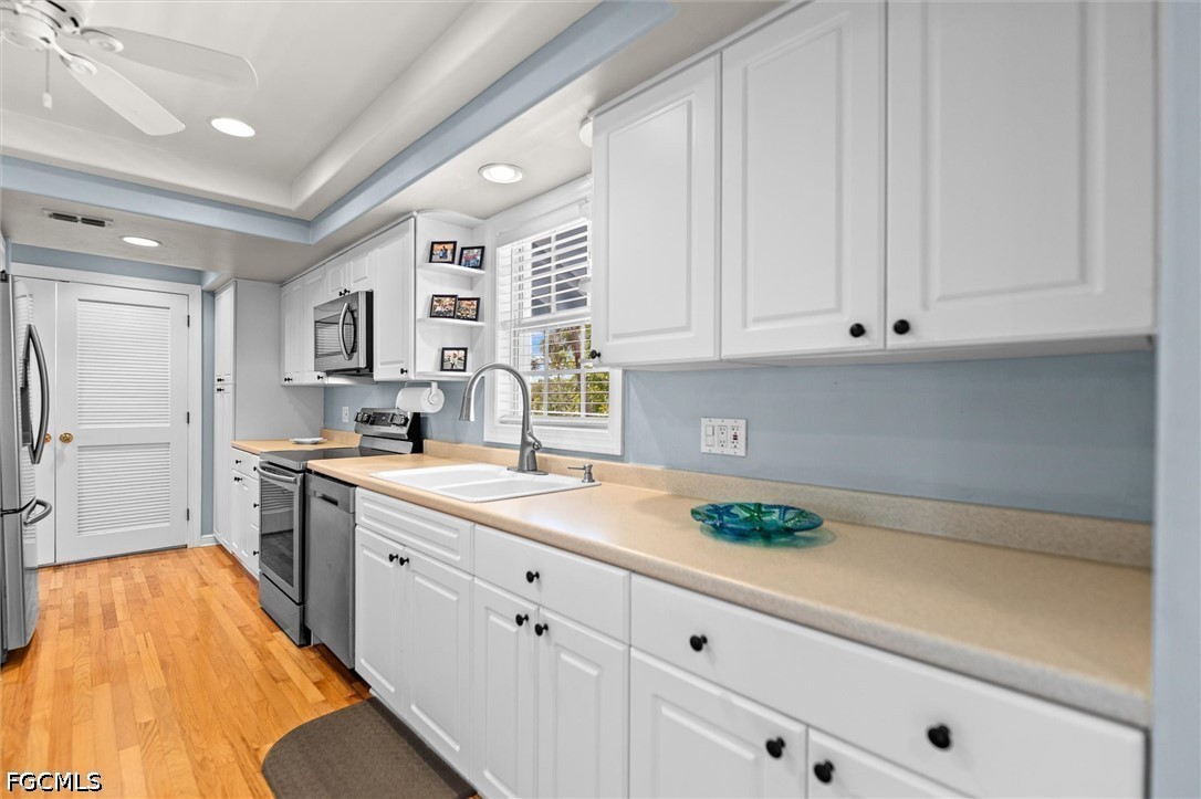 5304 Ladyfinger Lake Road Sanibel, FL 33957 - Photo 8 of 48 a kitchen with stainless steel appliances white cabinets and a sink