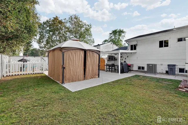 a view of a house with backyard and sitting area