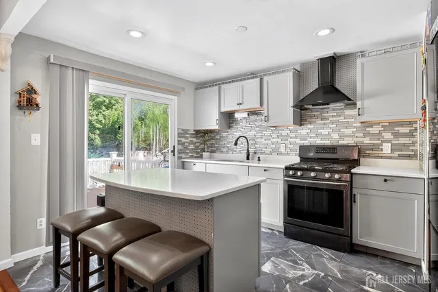 a kitchen with stainless steel appliances granite countertop a stove a sink and a refrigerator