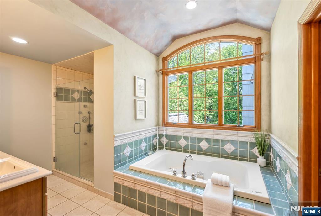 411 Snyder Road Wyckoff, NJ 07481 - Photo 20 of 36 a bathroom with a tub a sink and a large window