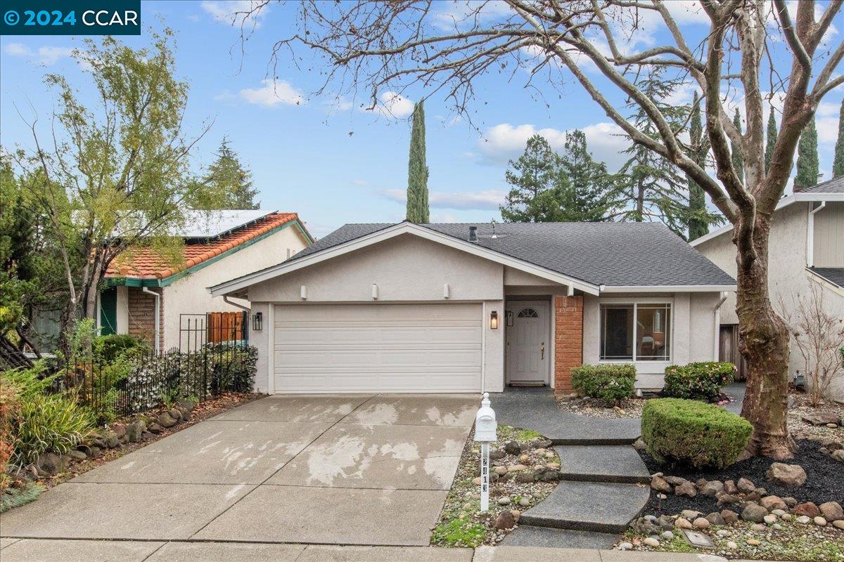 a front view of house with yard and trees around