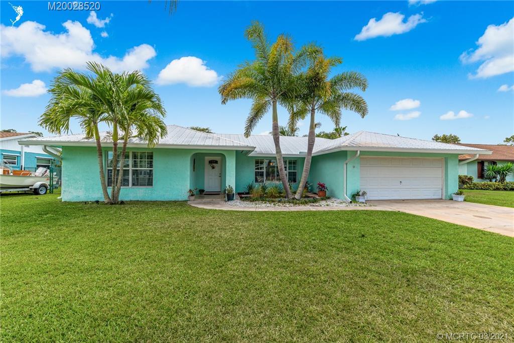 4780 Southeast Glen Ridge Trail Stuart, FL 34997 - Photo 1 of 31 a front view of a house with a garden and patio