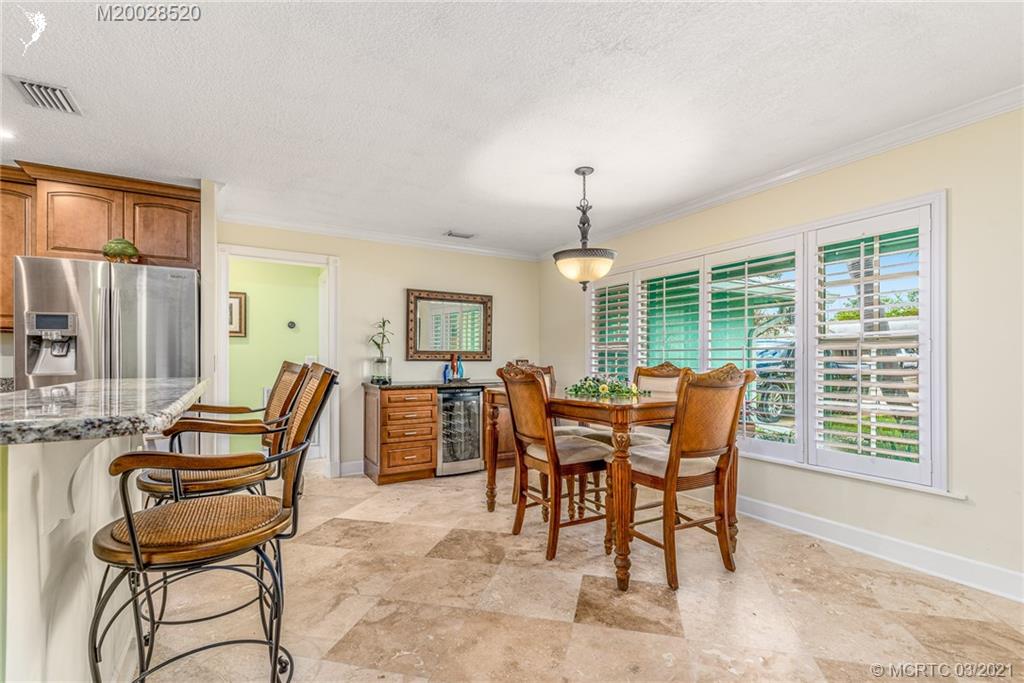 4780 Southeast Glen Ridge Trail Stuart, FL 34997 - Photo 14 of 31 a dining room with furniture a chandelier and wooden floor