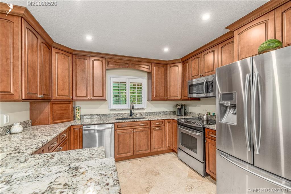4780 Southeast Glen Ridge Trail Stuart, FL 34997 - Photo 17 of 31 a kitchen with stainless steel appliances granite countertop a sink stove refrigerator and cabinets