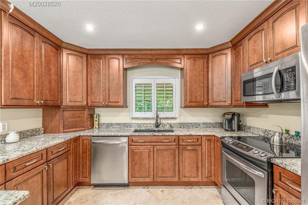 4780 Southeast Glen Ridge Trail Stuart, FL 34997 - Photo 18 of 31 a kitchen with stainless steel appliances granite countertop a stove a sink dishwasher and a microwave
