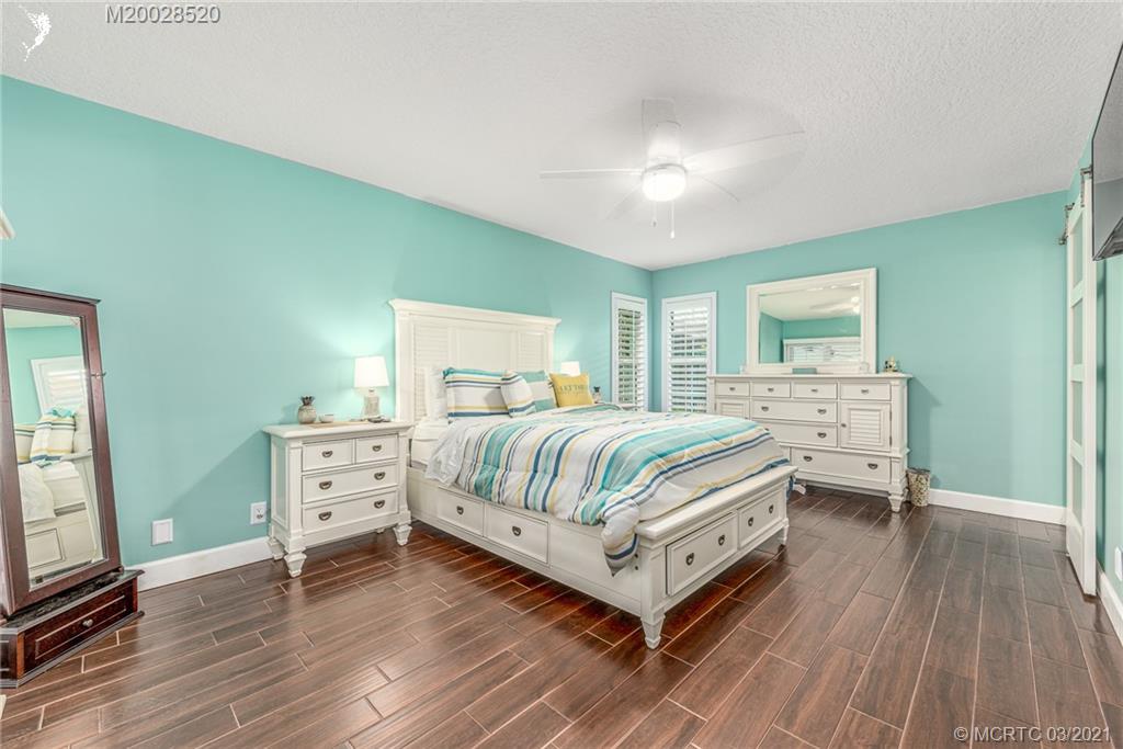 4780 Southeast Glen Ridge Trail Stuart, FL 34997 - Photo 19 of 31 a bedroom with a bed and a flat tv screen on dresser