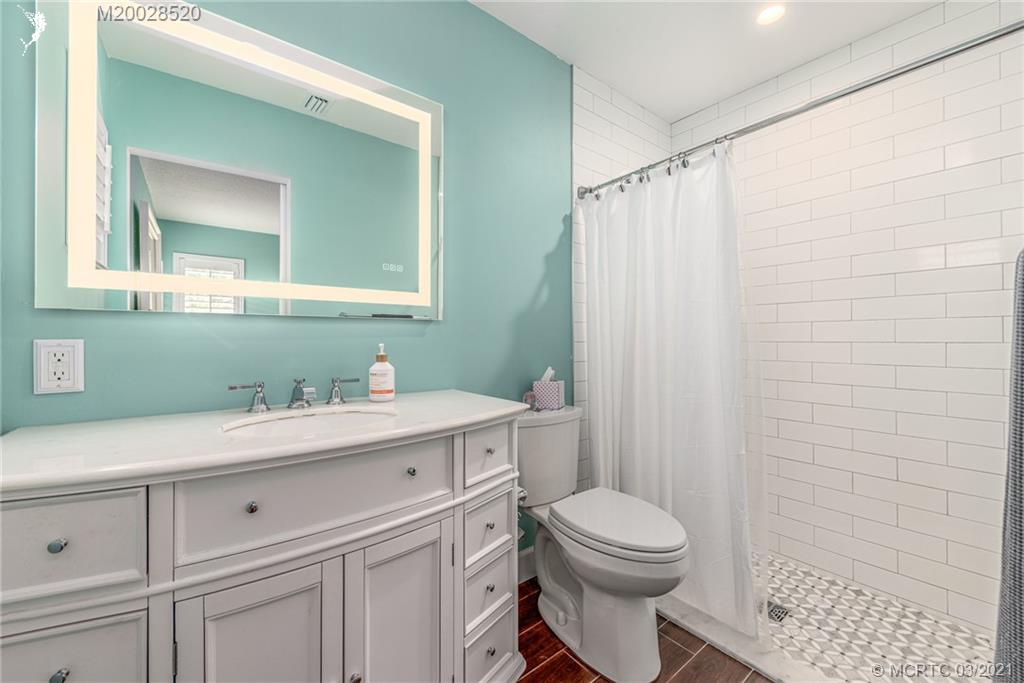 4780 Southeast Glen Ridge Trail Stuart, FL 34997 - Photo 22 of 31 a bathroom with a sink a toilet and shower