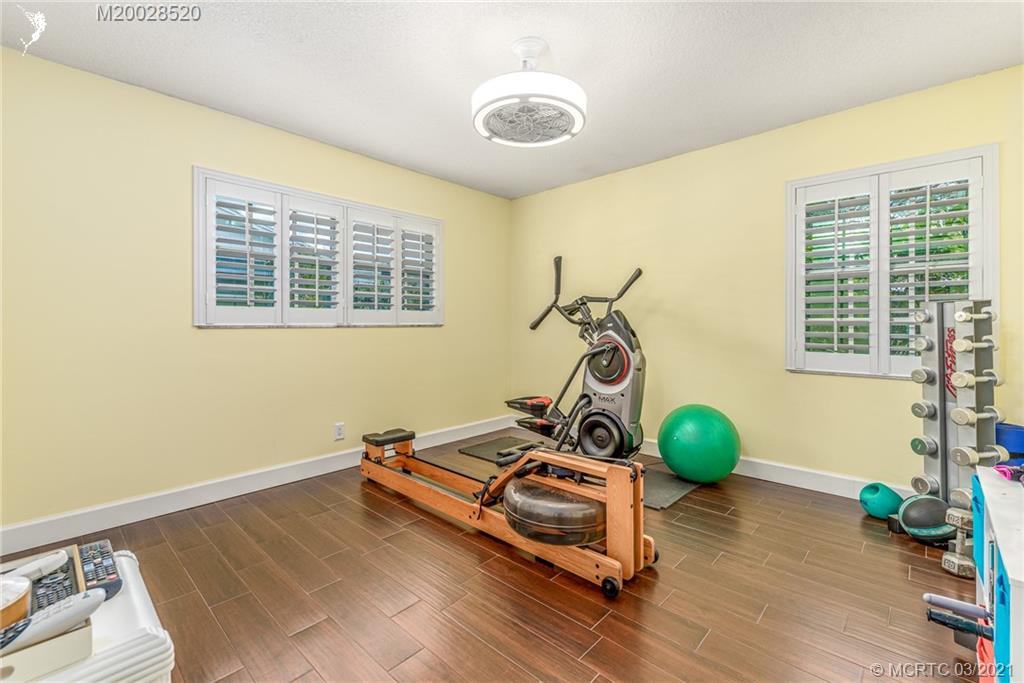4780 Southeast Glen Ridge Trail Stuart, FL 34997 - Photo 24 of 31 a room with gym equipment and windows