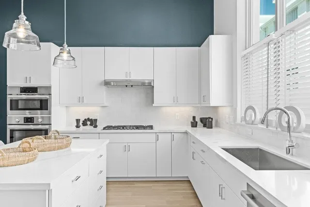 a kitchen with cabinets appliances a sink and a counter top space