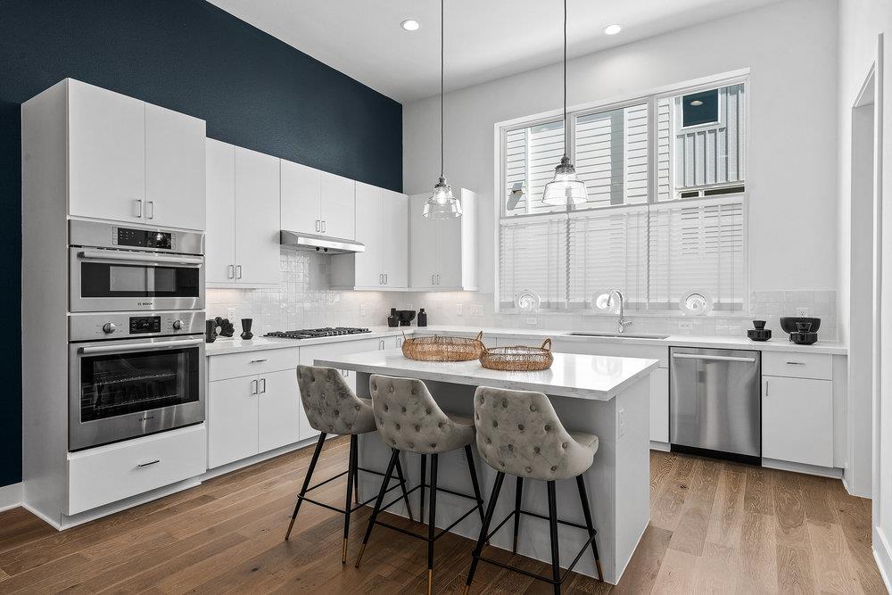 2805 McCurdy Street, Unit 4 Austin, TX 78723 - Photo 8 of 40 a kitchen with stainless steel appliances granite countertop a stove a sink dishwasher a oven with white cabinets and wooden floor