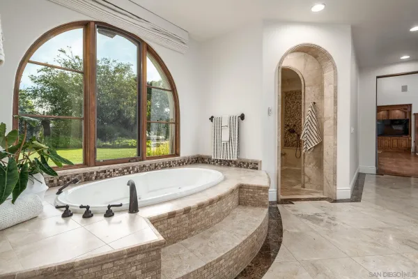 a spacious bathroom with a tub and a large window