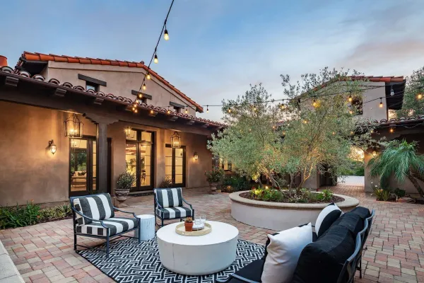 a view of a patio with couches table and chairs and potted plants