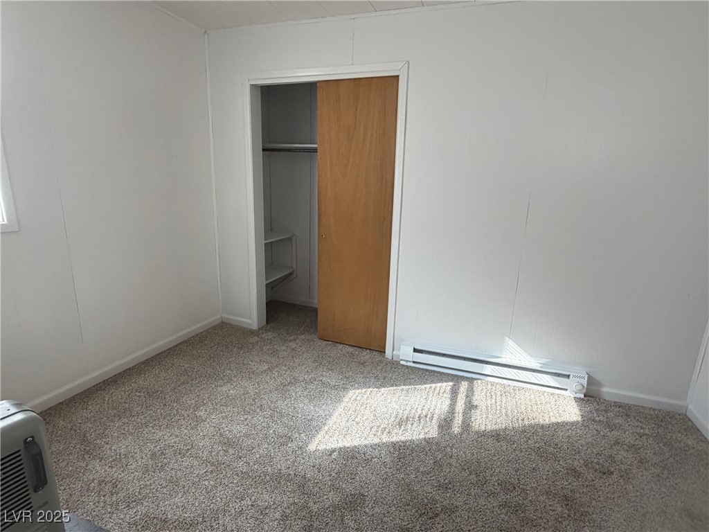 1144 Ave D Ely, NV 89301 - Photo 11 of 15 bedroom with light carpet, baseboard heating, and a closet