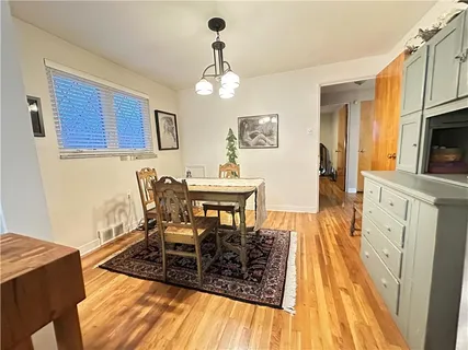 a view of a dining room with furniture a chandelier and wooden floor