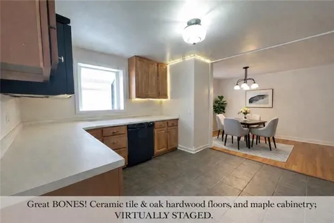 a open kitchen with granite countertop a stove dining table and chairs