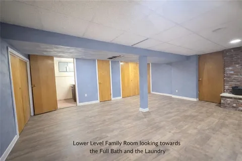 a view of an empty room with window and a fireplace