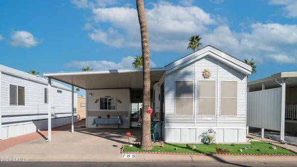 a view of a house with a yard and table and chairs