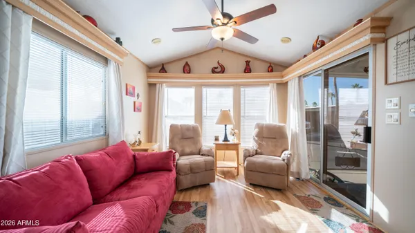 a living room with furniture ceiling fan and a large window