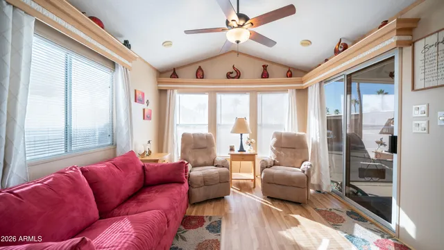 a living room with furniture ceiling fan and a large window