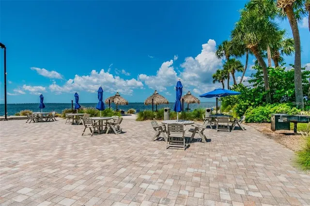 a room with lots of white furniture a rug and a book shelf