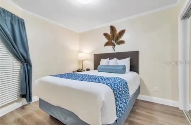 a bedroom with a bed and a painting on the wall