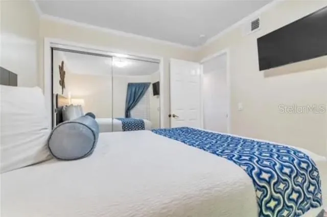 a bedroom with a large bed and a flat tv screen on the dresser