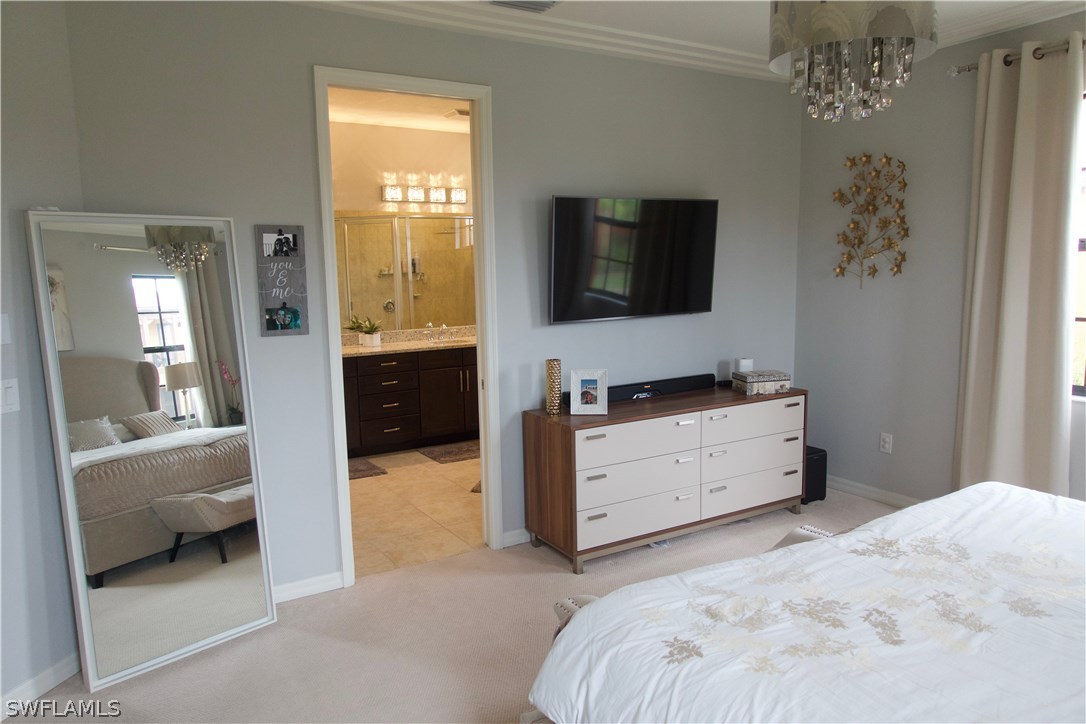 11845 Palba Way, Unit 7301 Fort Myers, FL 33912 - Photo 13 of 19 a bedroom with a bed and a television