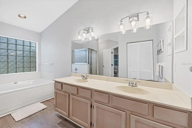 a bathroom with a sink double vanity granite tub and a mirror