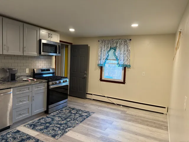 a kitchen with stainless steel appliances granite countertop a refrigerator stove top oven and sink