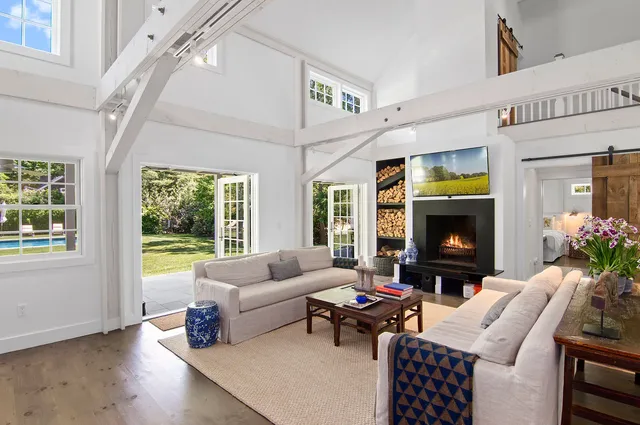 a living room with furniture a fireplace a rug and a window