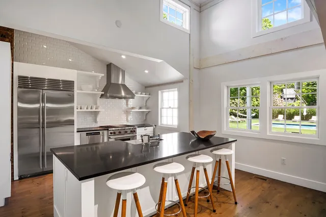 a kitchen with a kitchen island a stove a table and chairs in it