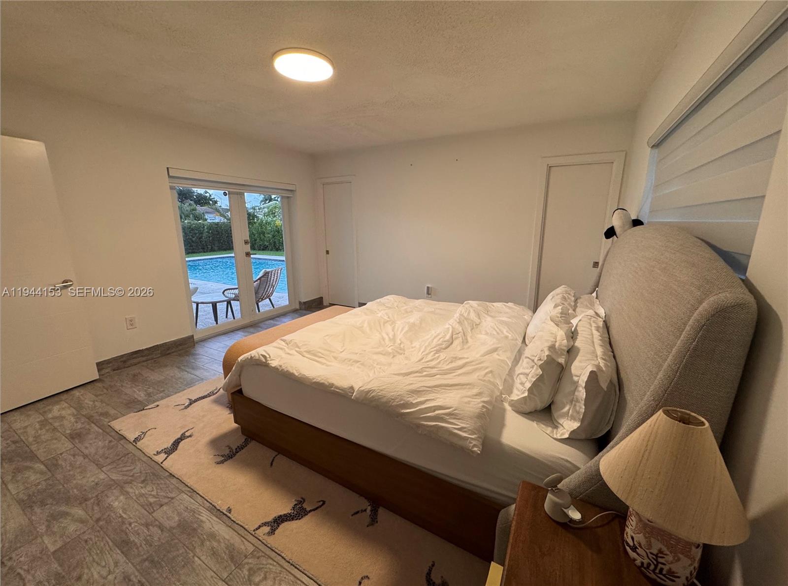 1881 Northeast 210th Street Miami, FL 33179 - Photo 12 of 29 a bed sitting in a bedroom next to a window