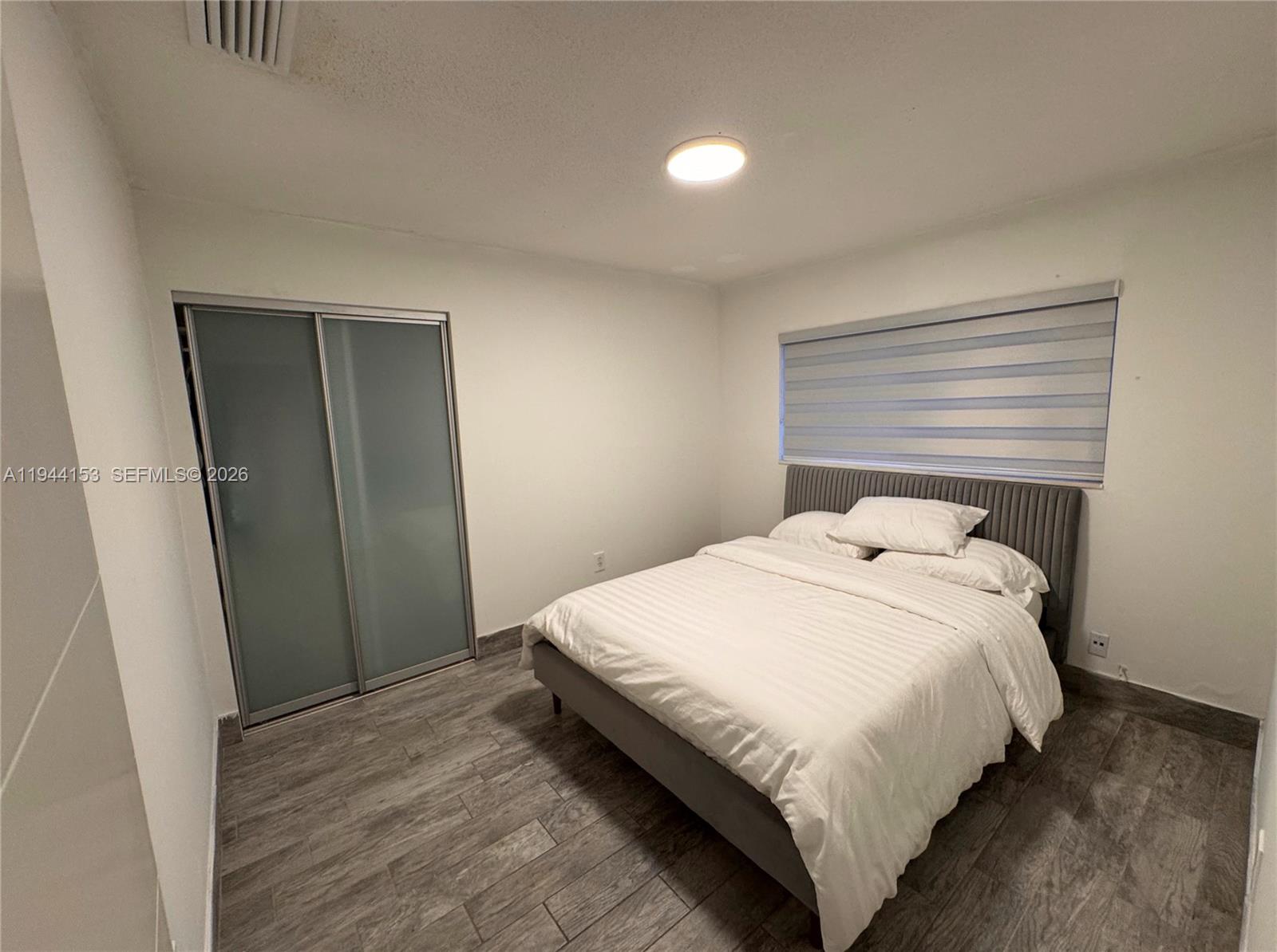 1881 Northeast 210th Street Miami, FL 33179 - Photo 14 of 29 a bedroom with a bed and a window