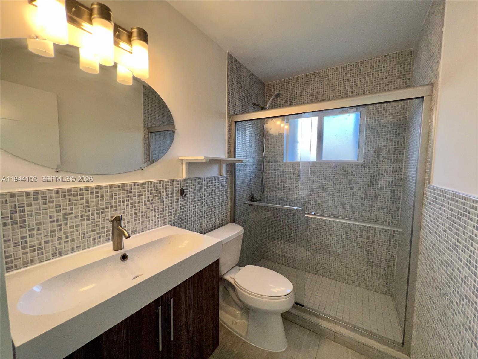 1881 Northeast 210th Street Miami, FL 33179 - Photo 23 of 29 a bathroom with a sink a toilet and shower