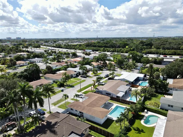 an aerial view of residential houses with outdoor space and parking