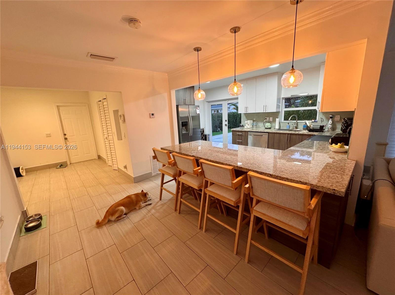 1881 Northeast 210th Street Miami, FL 33179 - Photo 8 of 29 a view of a dining room with furniture a chandelier and wooden floor