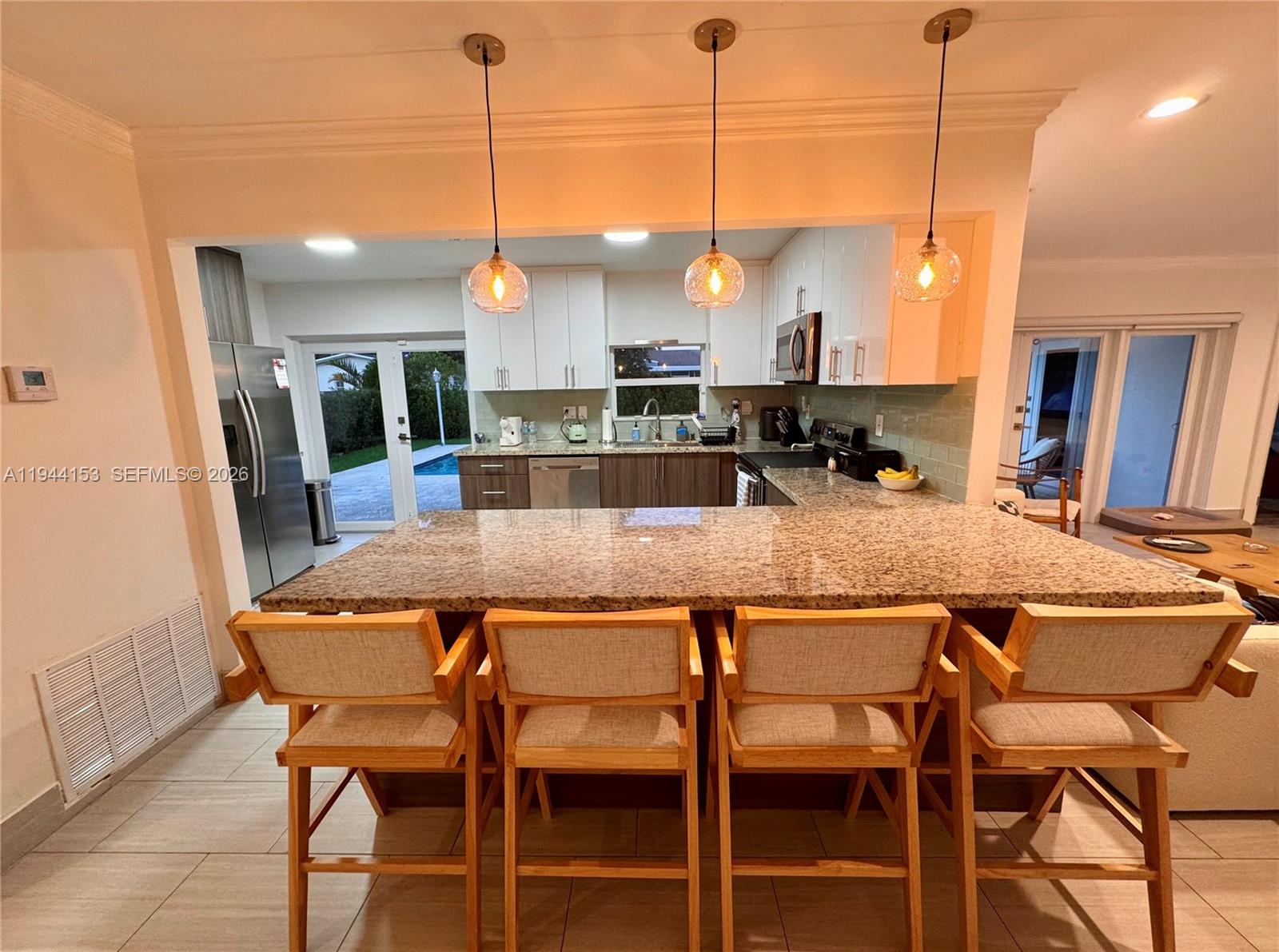 1881 Northeast 210th Street Miami, FL 33179 - Photo 9 of 29 a dining table with chairs and kitchen view