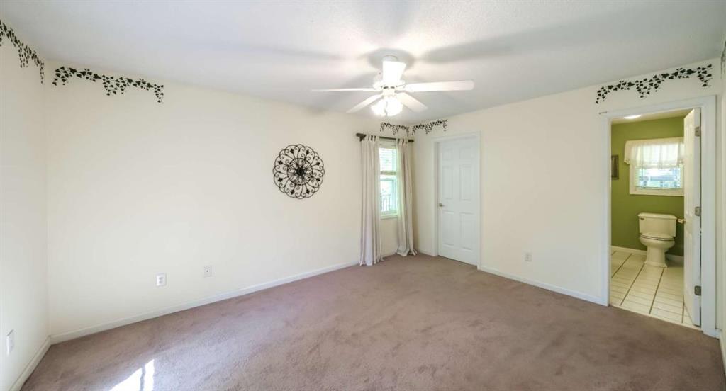 396 Pam Street Wedowee, AL 36278 - Photo 23 of 48 an empty room with a chandelier fan and a bathroom