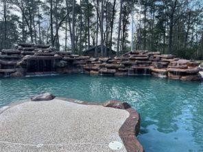 37 Robin Hood Cleveland, TX 77327 - Photo 17 of 20 a view of a lake with lawn chairs and large trees