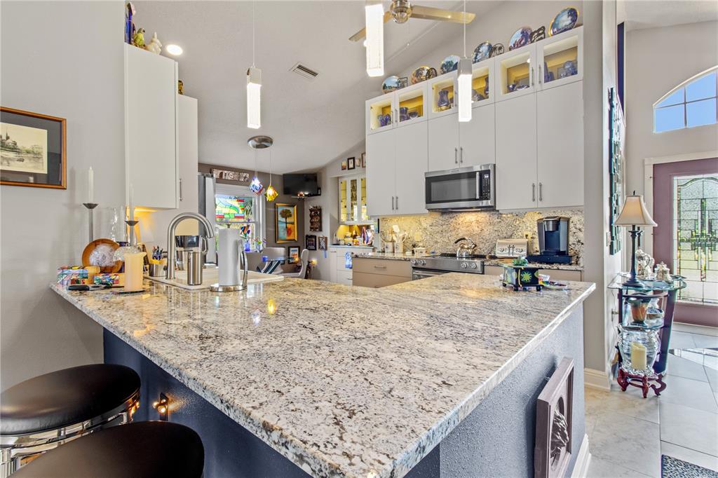 70 Center Oak Circle Spring Hill, FL 34609 - Photo 22 of 58 a kitchen with granite countertop a sink a counter top space and living room view