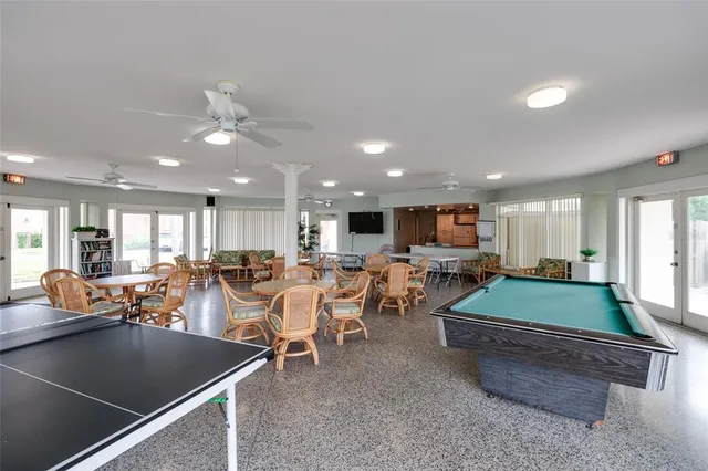 a room with stainless steel appliances lots of wooden furniture dining table and chairs