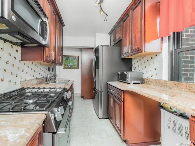 a kitchen with stainless steel appliances granite countertop a stove top oven a sink a refrigerator and dishwasher