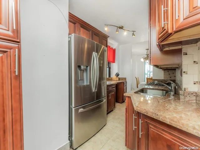 a kitchen with stainless steel appliances granite countertop a refrigerator and a sink